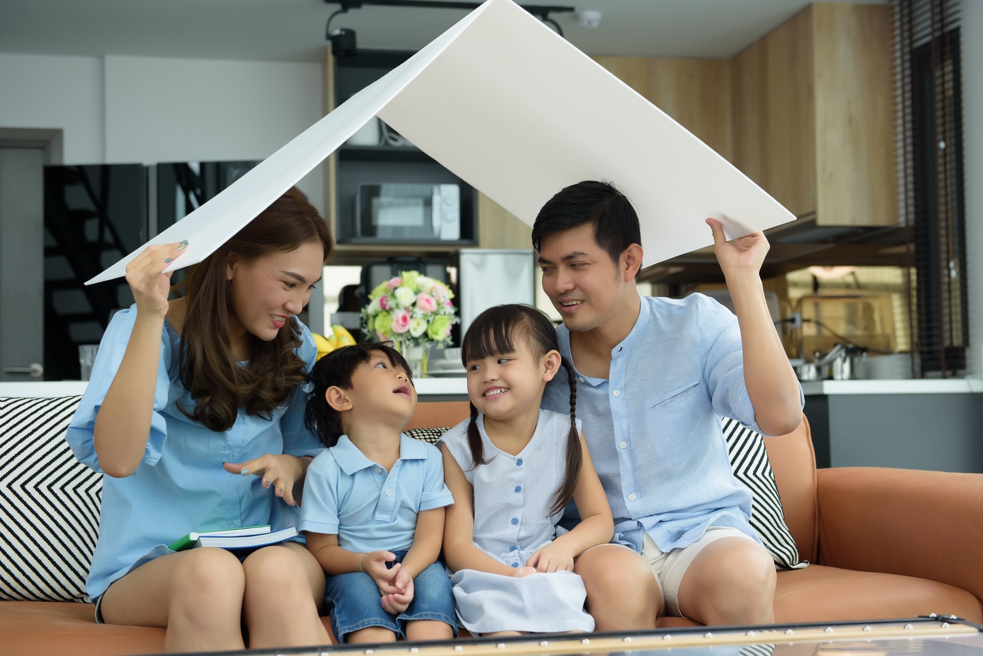 Asian young family happy to playing housing, Mother with Father and Children at living room in new home. New life family, Stable housing concept. Soft focus on Children center.