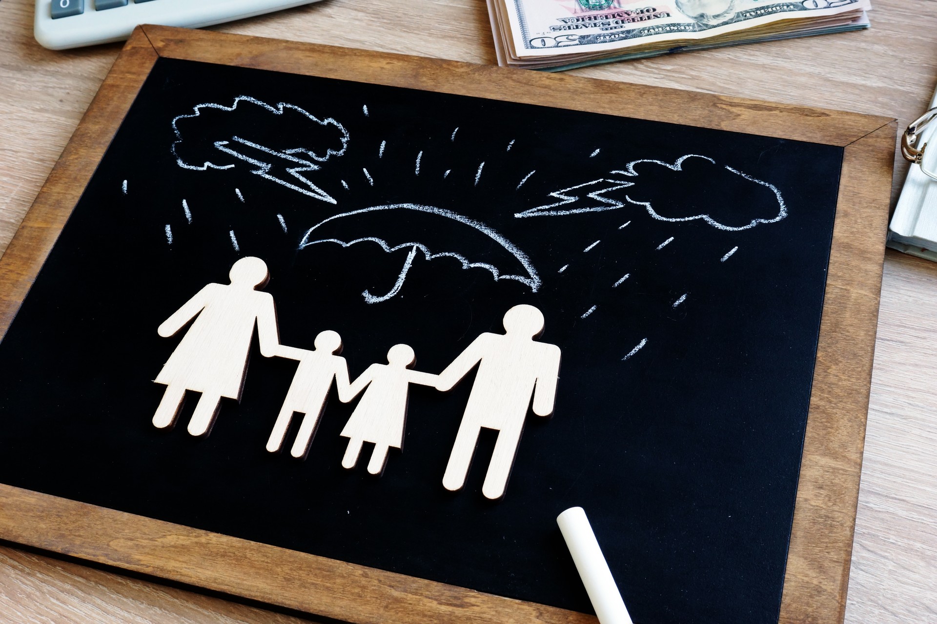 Health and life insurance. Blackboard with family figures in the agency.